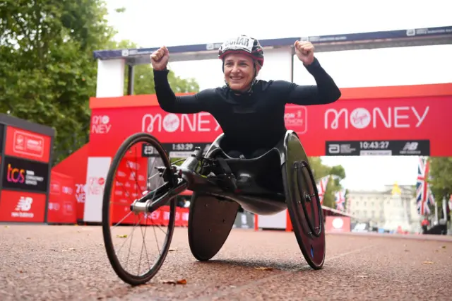 Manuela Schar raises her hands in celebration at the finish line