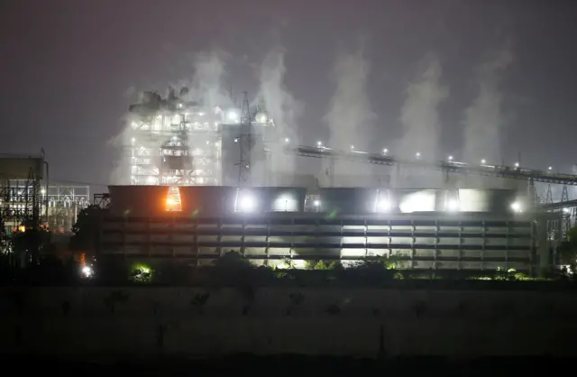 Smoke billows from the cooling towers of a coal-fired power plant in Ahmedabad