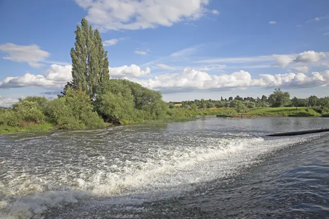 White water from the weir on the River Avon in the Vale of Evesham, Fladbury, Worcestershire,