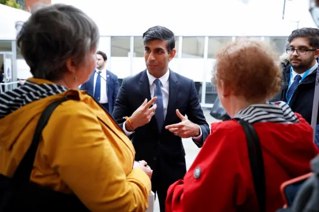 Rishi Sunak talks to delegates outside the conference centre after his speech on Tuesday