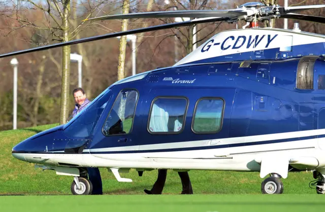 Mike Ashley leaves a helicopter