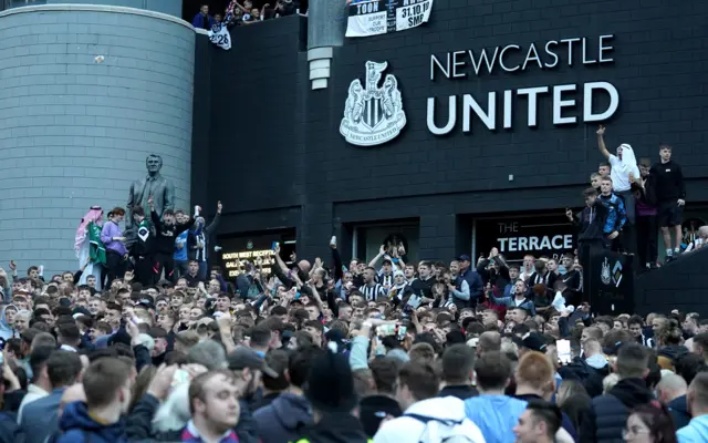 Fans celebrate outside St James's Park following the takeover news