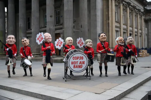 involving Oxfam activist dressed with Scottish kilts, bagpipes and drums and wearing masks of major presidents and prime ministers take part in a protest at Royal Exchange Square during the COP26 UN Climate Summit in Glasgow on November 1, 2021