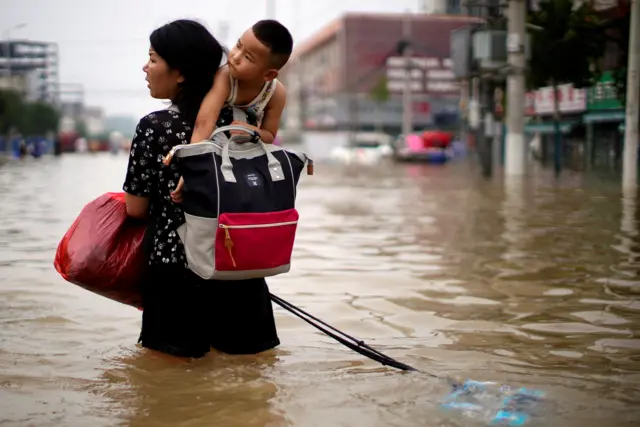 A woman and child during floods in Zhengzhou in July