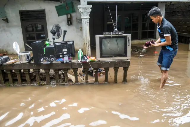 Resident of Jakarta rescues belongings from floodwaters in 2020