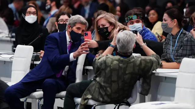 US Special Presidential Envoy for Climate, John Kerry takes selfies with audience members ahead of a speech by former US president Barack Obama during the Cop26 summit at the Scottish Event Campus (SEC) in Glasgow.