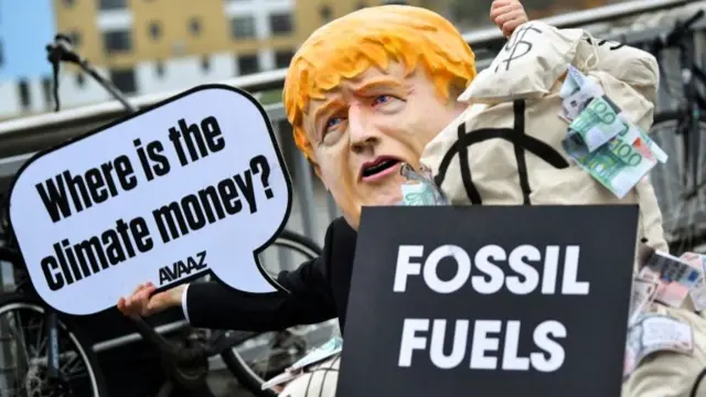 A person wearing a Boris Johnson mask during protests outside the COP26 summit