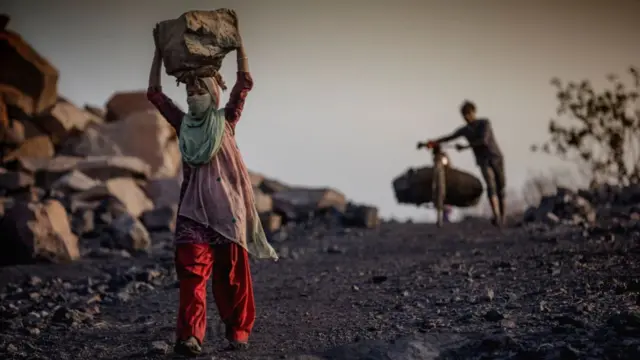 A girl carrying coal