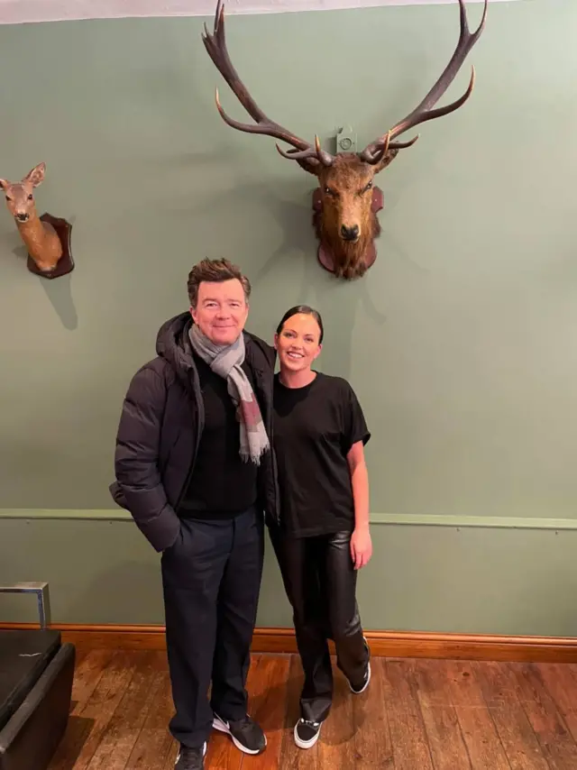 Rick Astley with a member of staff