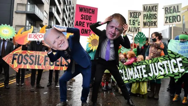 Protesters dressed in masks of US President Joe Biden and UK Prime Minister Boris Johnson