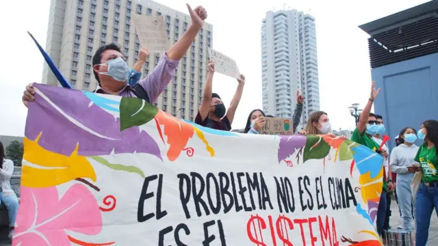 Group of demonstrators with a banner that reads "The problem is not the climate, it is the system"