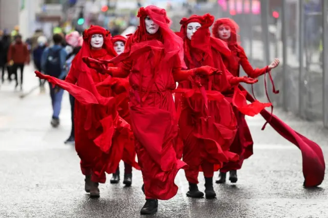 Members of Extinction Rebellion Red Rebel Brigade protest at COP26