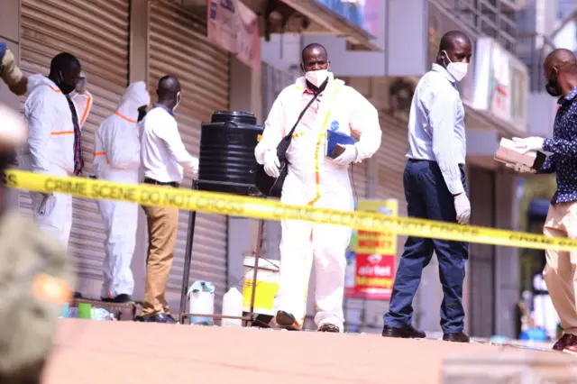 Police officers inspect around sites after two blasts occurred with one just meters away from the main gate to the country's parliament and the other near the city's central police station,