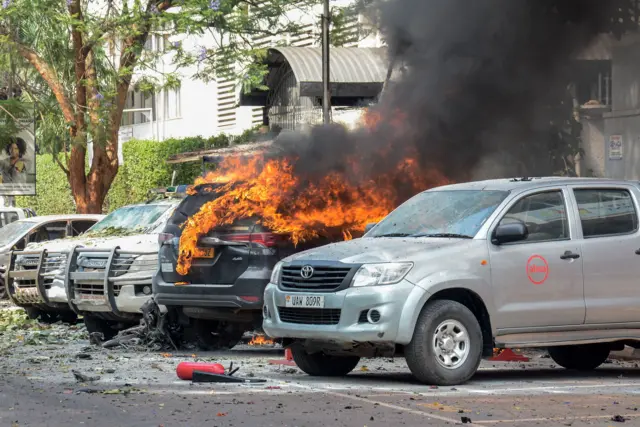 Cars are on fire after a bomb explosion near the Parliament building in Kampala, Uganda, on November 16, 2021