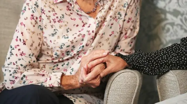 File image of an elderly woman having her hand held