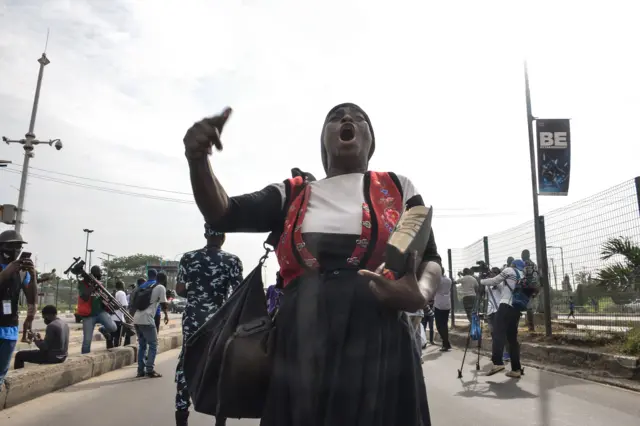 A female preacher holding Holy Bible eco slogans during civil demonstration at the Gani Fahweyinmi Park, Ojota district of Lagos, Nigeria, on 12 June 2021