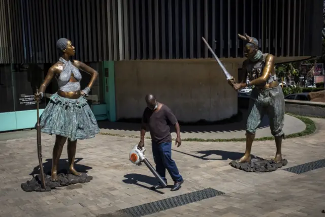 A caretaker uses a leaf blower between two new bronze sculptures by South African artist Nandipha Mntambo at the Circa Gallery as part of the Keyes Art Mile in Johannesburg, South Africa, 18 November 2021. The street has become an art mile involving galleries such as Circa and Everard Read as well as various restaurants that bring the public to the street in the heart of the Rosebank area of Johannesburg