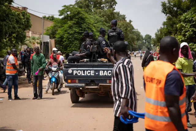 Police officers drive on a vehicle during a march called by the opposition to protest against the security situation worsening and asking for a response to jihadist attacks, in Ouagadougou, on July 3, 2021.