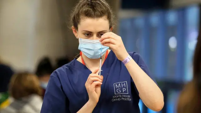 A woman prepares a vaccine dose