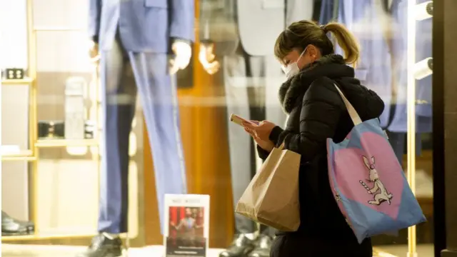 A woman walking past a shop