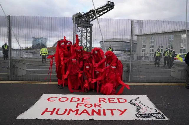 Red Rebel Brigade carry out protest - with banner reading "Code Red for humanity"