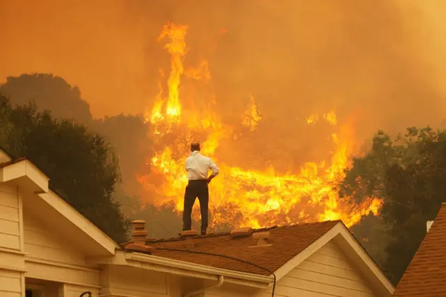 Man on roof watching wildfires