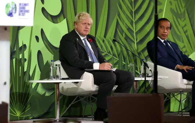 British Prime Minister Boris Johnson and President of Indonesia Joko Widodo seated onstage during an Action on Forests and Land Use event on day three of COP26 on November 02, 2021 in Glasgow,