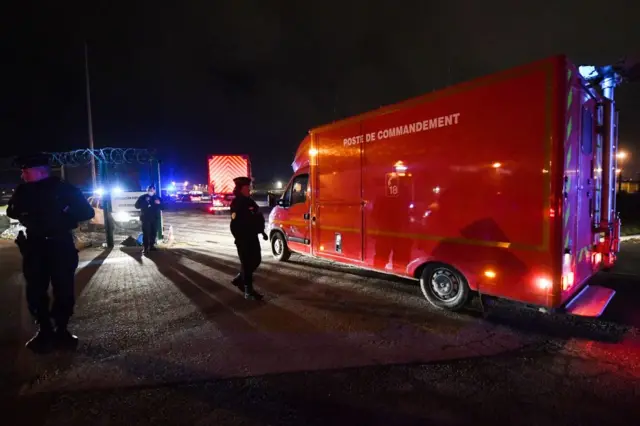 Police officers stand next to a fire command centre arriving at Calais harbour