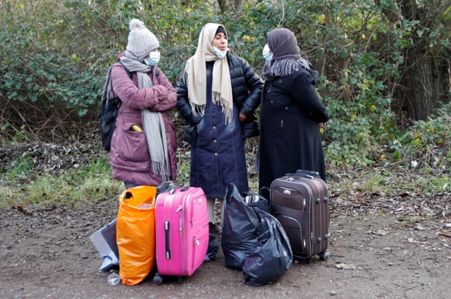 Three migrant women with suitcases