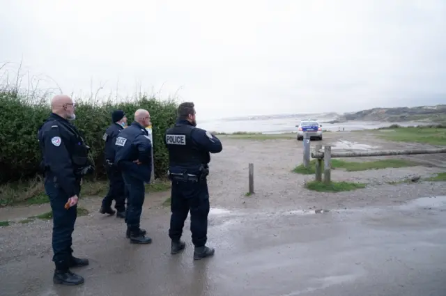 French police look out over a beach near Wimereux in France