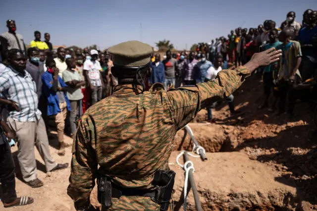 A military official talks with people, who are angry about the organisation of the burial and the sate of the graves in the military section at Gounghin Cemetery in Ouagadougou