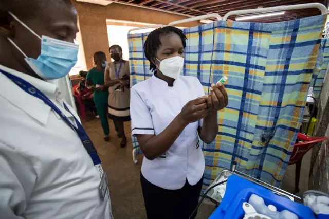 Health worker filling a syringe