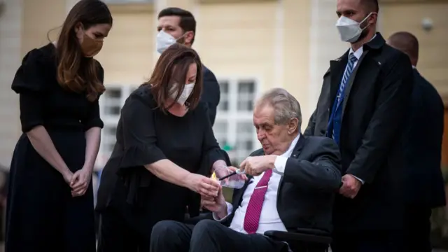 Czech President Milos Zeman lights a candle to commemorate victims of the Covid-19 pandemic at the Prague Castle