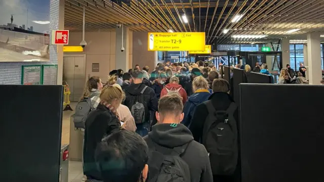 Passengers travelling from South Africa queue to be coronavirus disease (COVID-19) tested after being held on the tarmac at Schiphol Airport, Netherlands