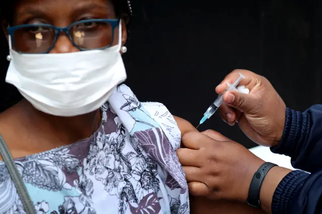 A healthcare worker administers the Johnson and Johnson coronavirus disease (COVID-19) vaccination to a woman in Houghton, Johannesburg, South Africa, August 20, 2021.