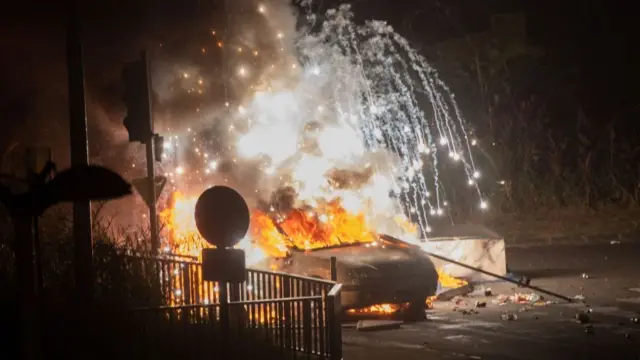 A car burns at a barricade blocking a bridge in Fort-de-France on the French Caribbean island of Martinique as hardline opponents of measures to limit the spread of Covid-19