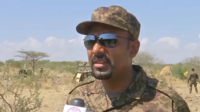 Prime Minister, Abiy Ahmed, in a rural location wearing a military uniform, after saying days ago that he would head to the frontline to direct the conflict.