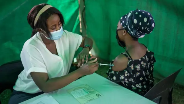 A healthcare worker administers the Johnson and Johnson vaccine to a woman in Soweto