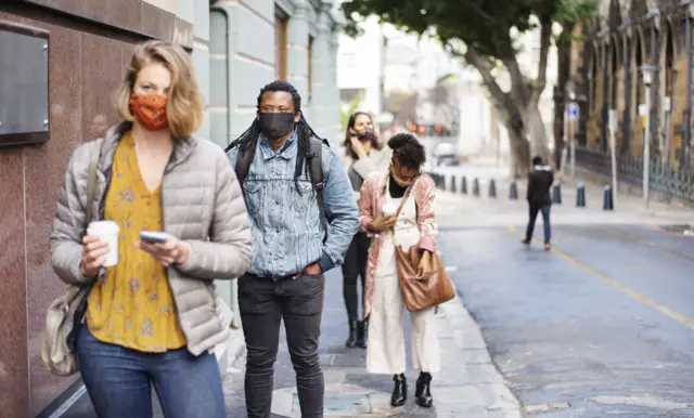 South African people wearing masks and socially distanced queueing