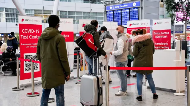 Travelers read information at a Covid-19 testing center at the departure area of the International Airport in Duesseldorf, Germany, 26 November 2021.