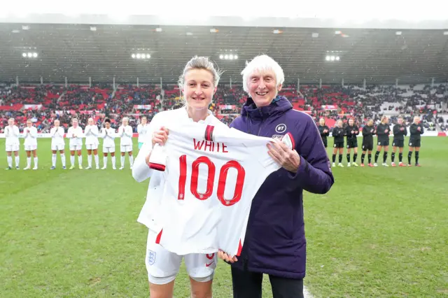 Ellen White is presented with a 100 shirt after making her 100th appearance for England