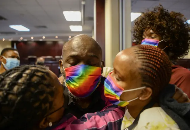 Activists wearing rainbows mask inside the Botswana High Court in Gaborone on November 29, 2021 embrace as they celebrate after the Botswana Court of Appeal dismissed the appeal by the government of Botswana against the Botswana High Court ruling of decriminalising homosexuality.