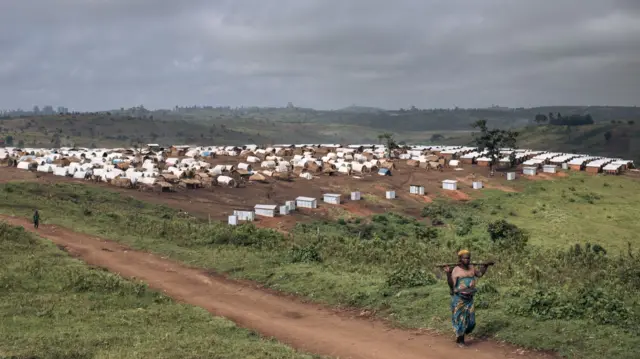 A woman walks near the Loda IDP camp, near Fataki, in Ituri province, northeastern Democratic Republic of Congo on September 16, 2020.