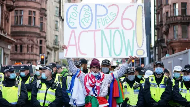 A protester in Glasgow holds up a sign