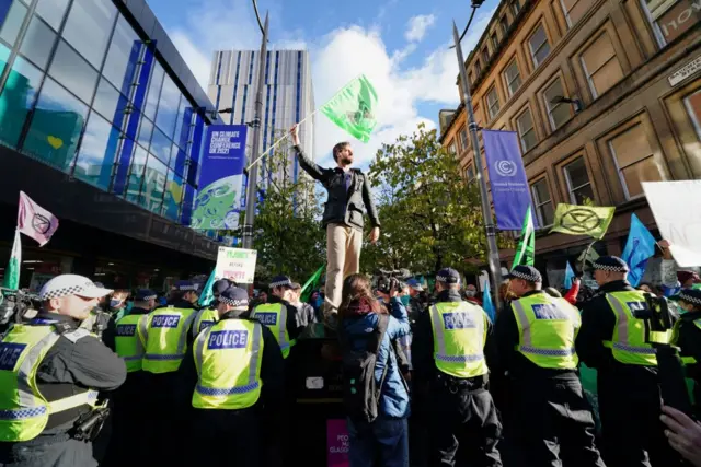 A protester waves a flag in front of police