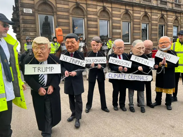 Climate protesters in George Square dressed in masks of world leaders