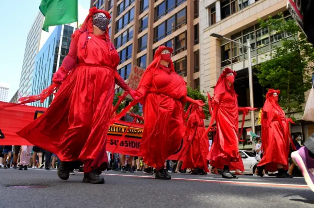 Extinction Rebellion protesters dress in red for the rally in Sydney