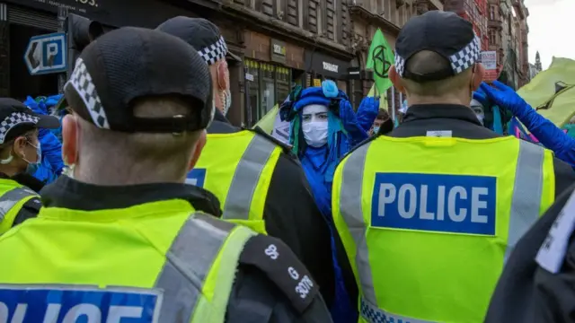 Police standing in front of protesters