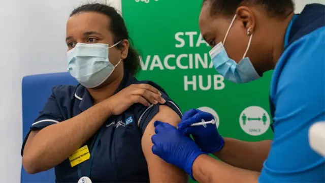 A nurse receiving a vaccine