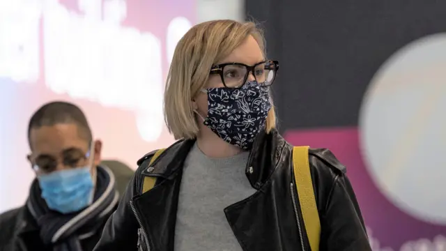 A woman in a mask at an aiport